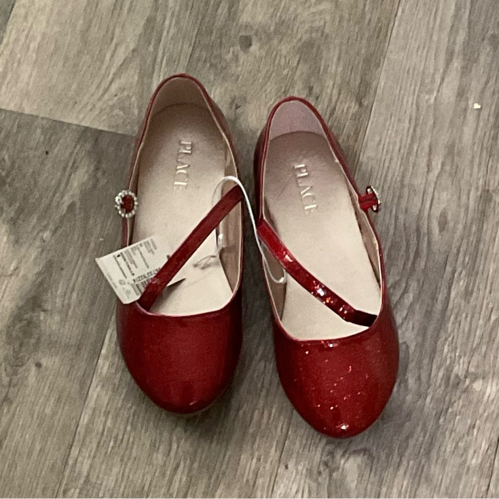 Children place red dress shoes size 1.